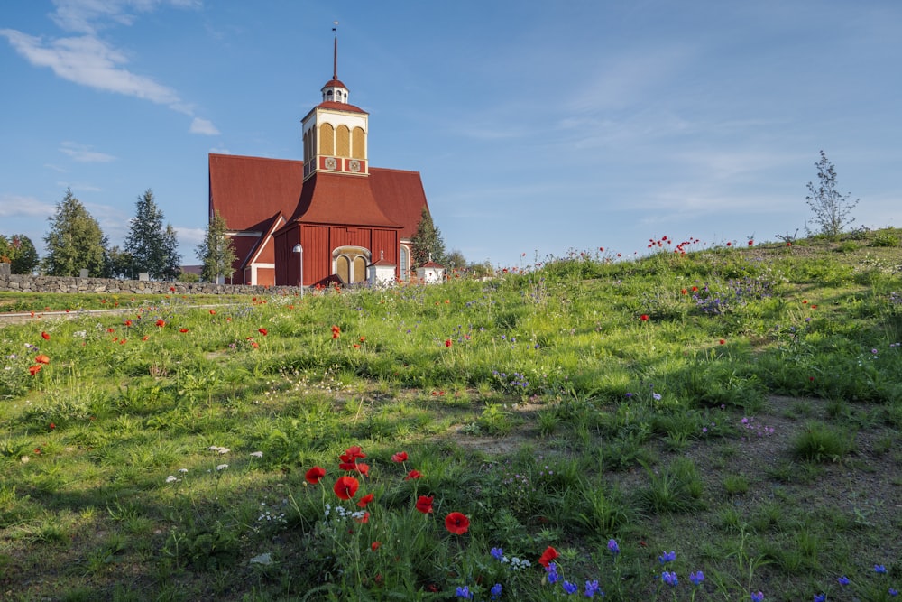 a red church with a steeple on a hill