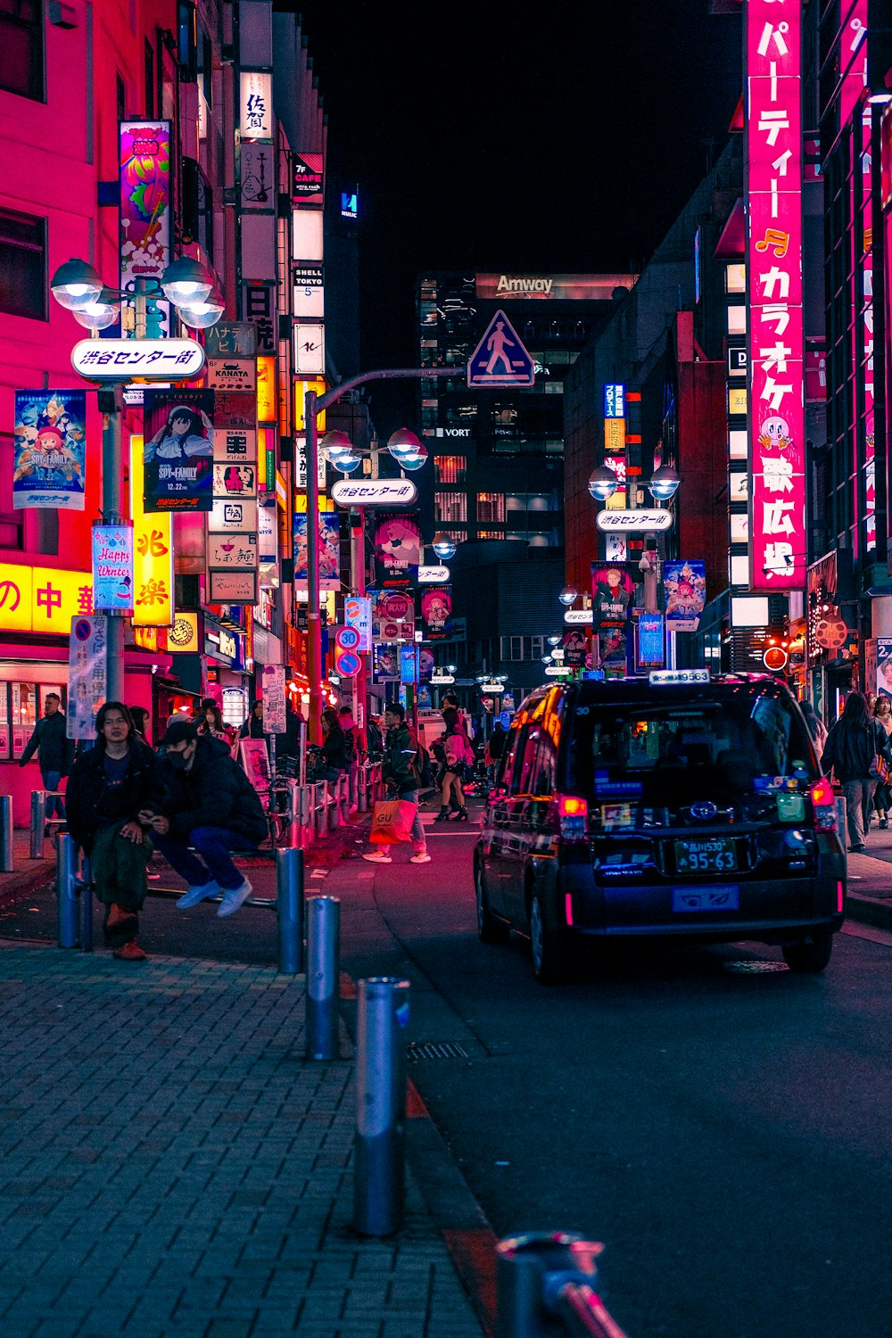 a busy city street at night with neon signs