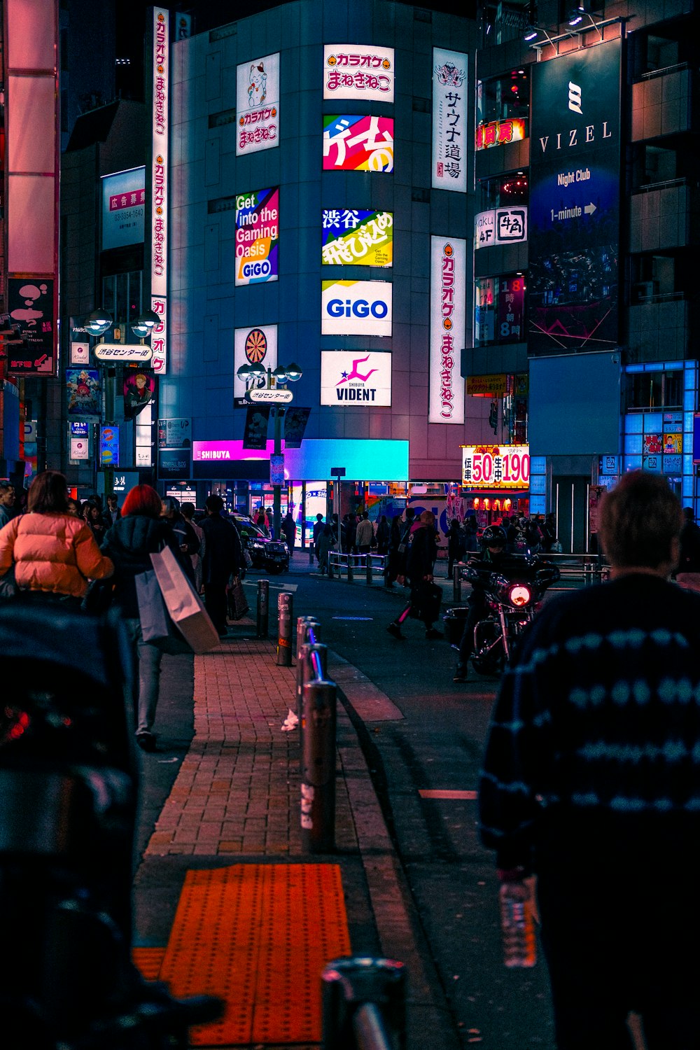 a city street at night with neon signs