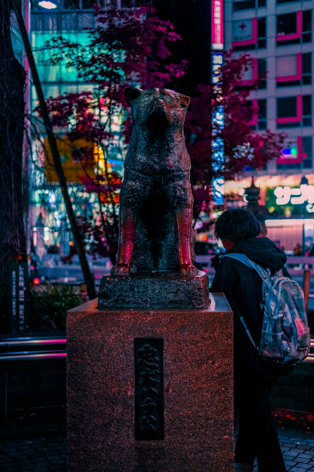 a person standing next to a statue of a dog
