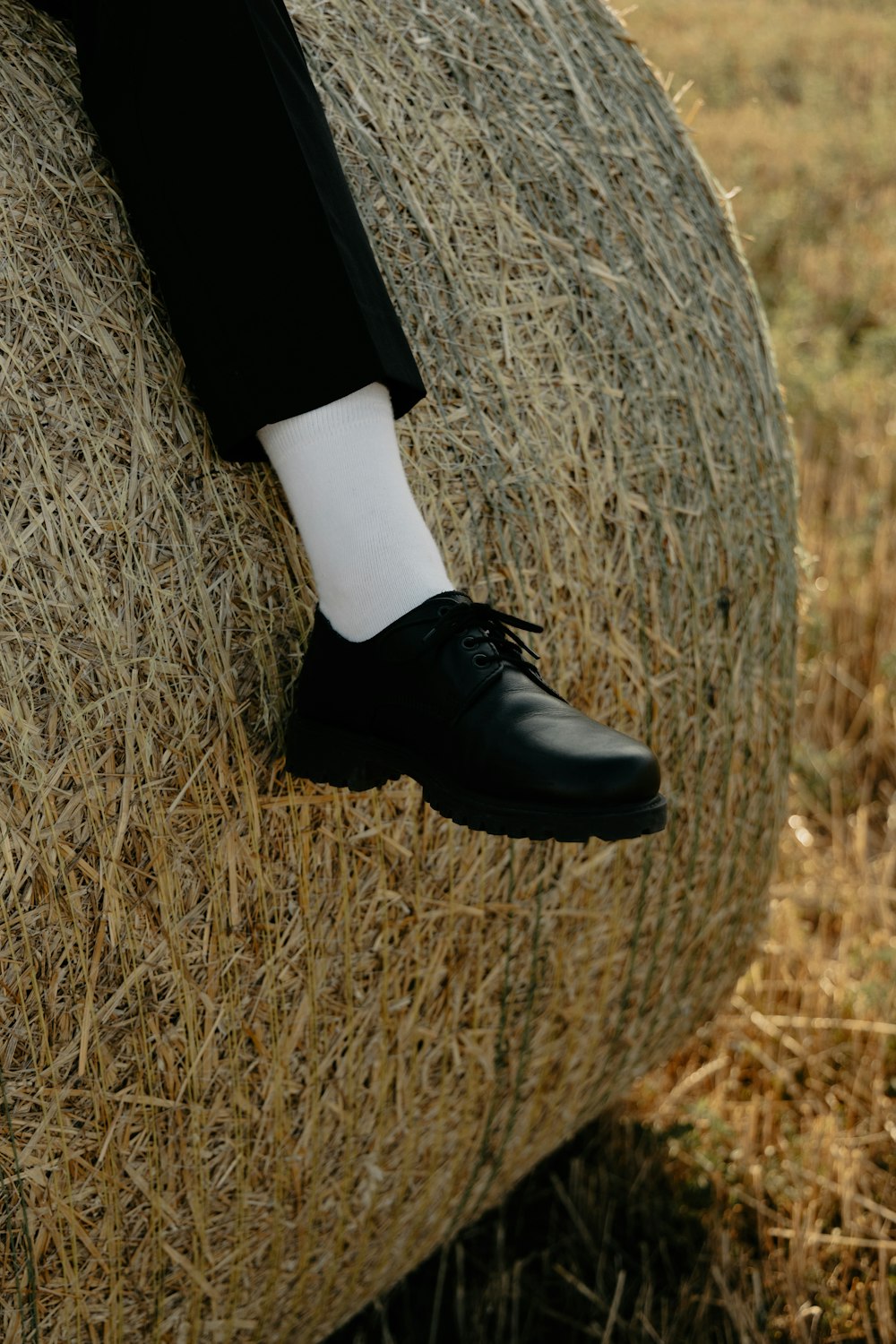 a person sitting on a bale of hay