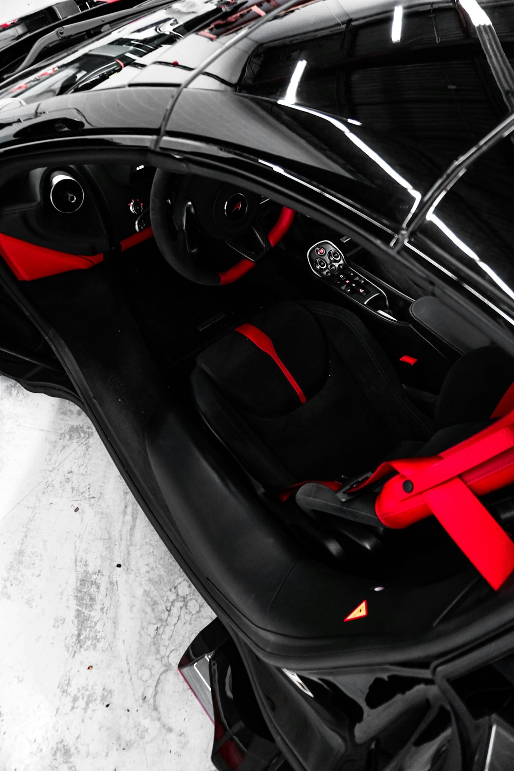 a black car with red trim and a steering wheel