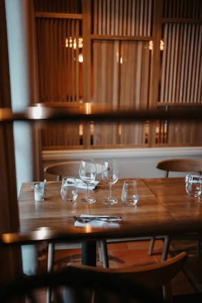 a wooden table topped with glasses of wine