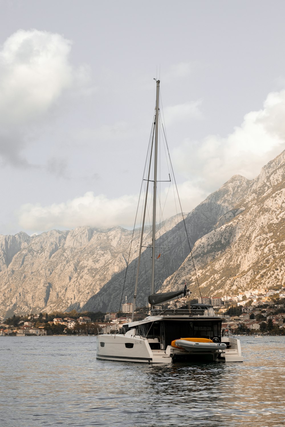 a sailboat in the water with mountains in the background