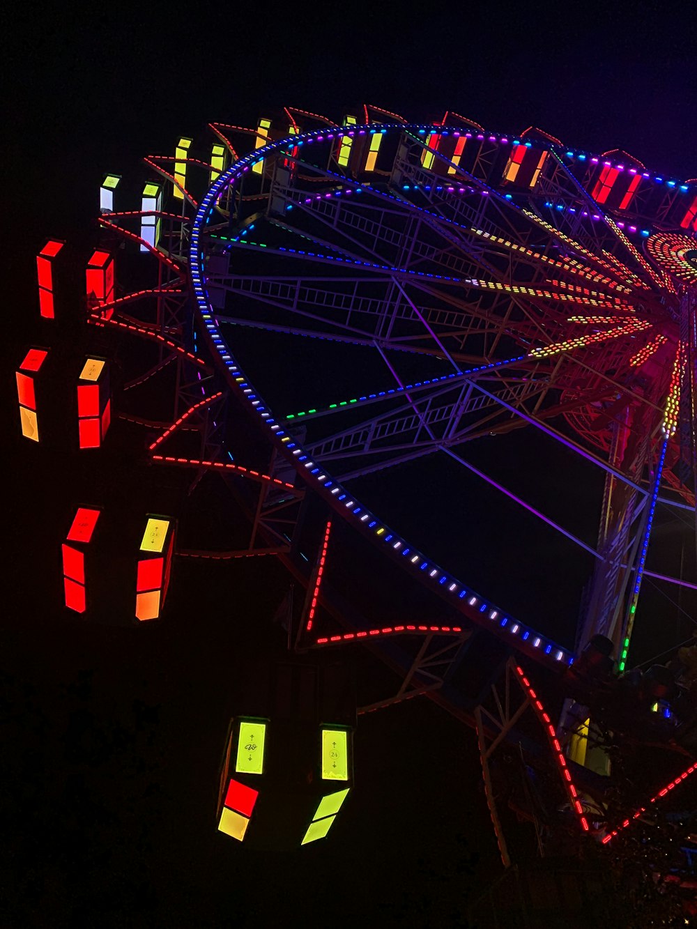 a ferris wheel lit up at night with colorful lights