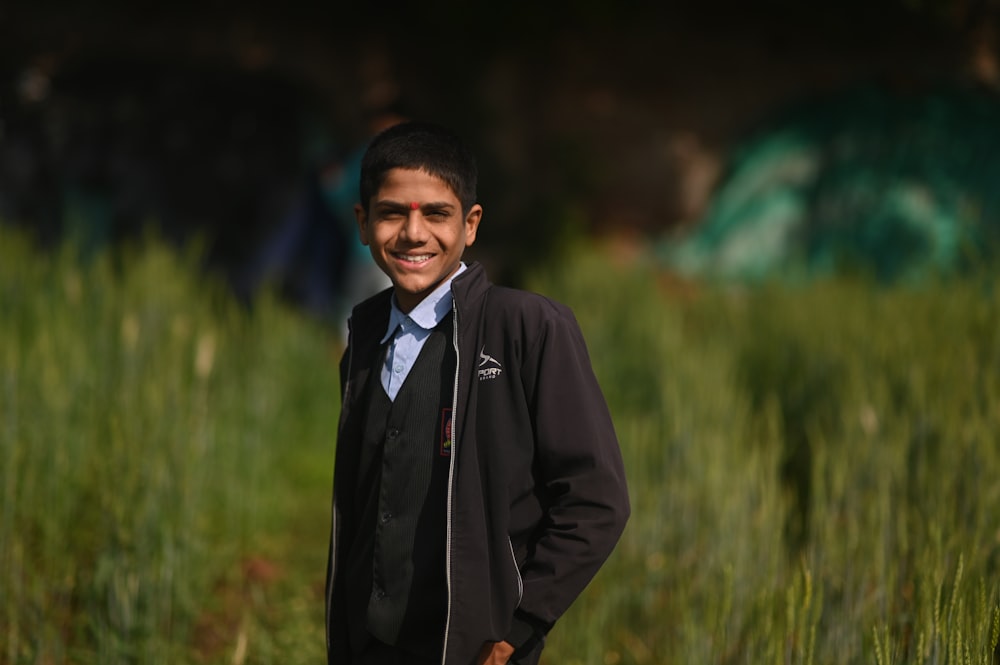 a young man standing in a field of tall grass