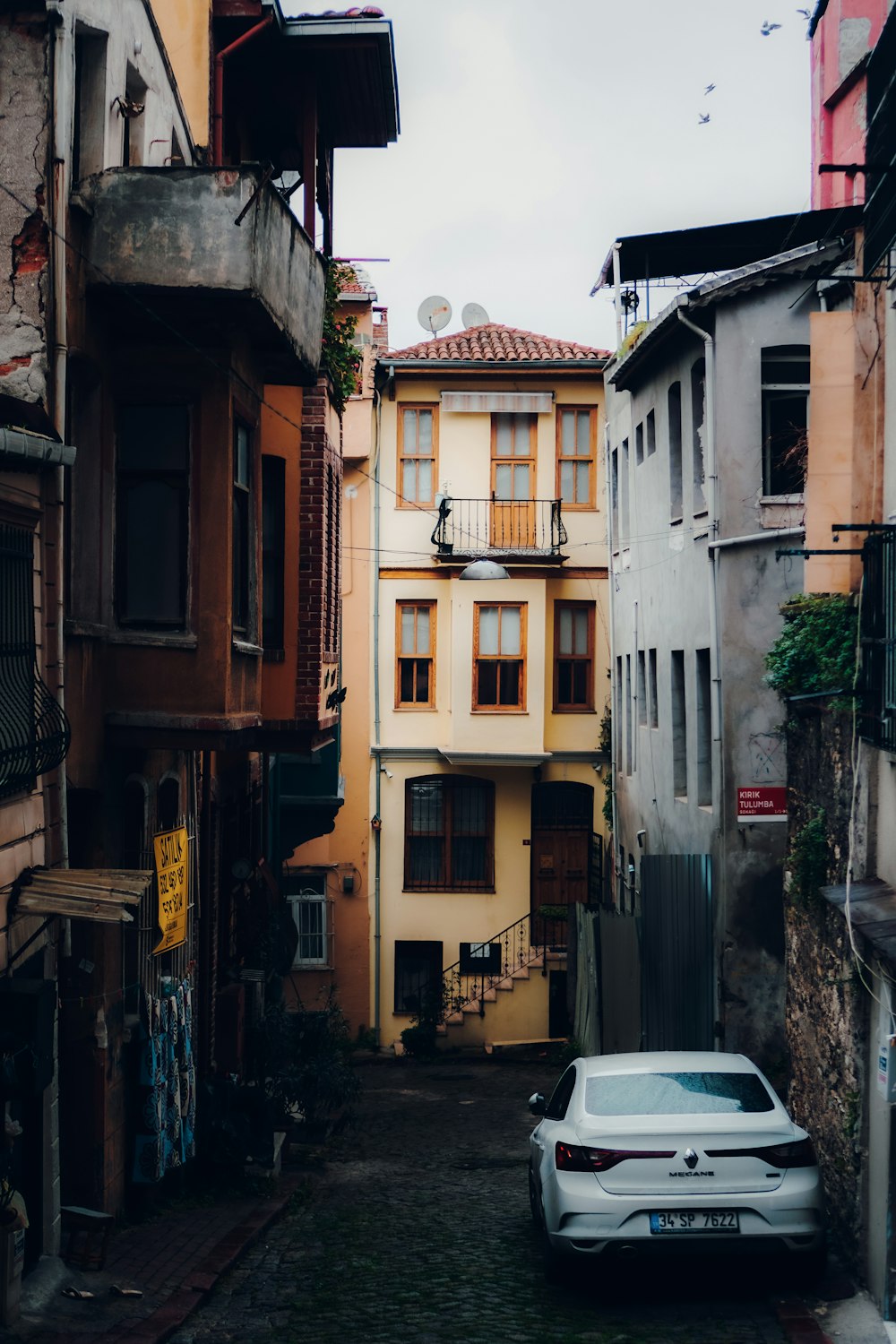 a white car parked in a narrow alley way