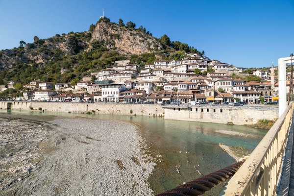 A river running through a city next to a hillside — Berat, Albania