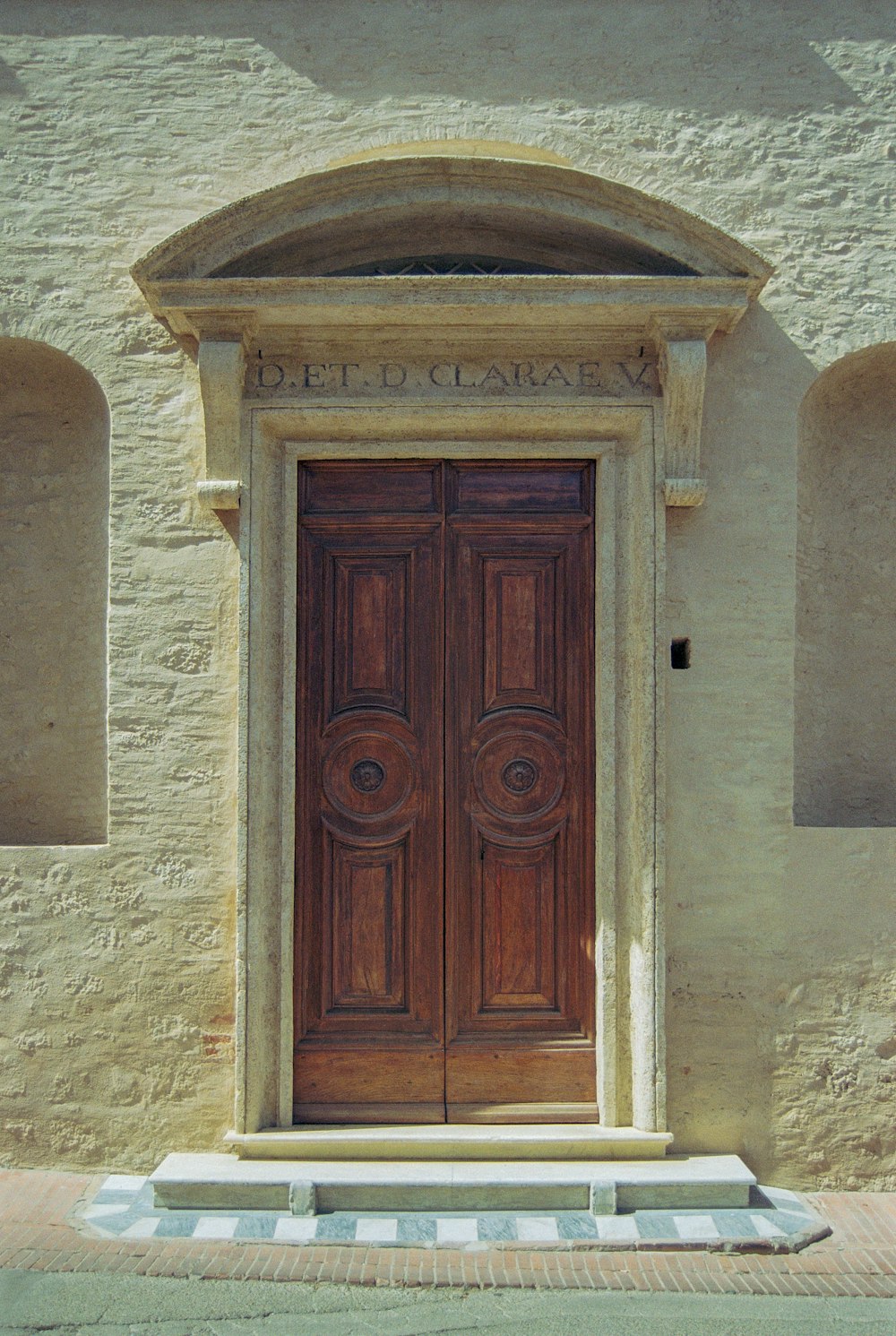une grande porte en bois assise devant un bâtiment en pierre