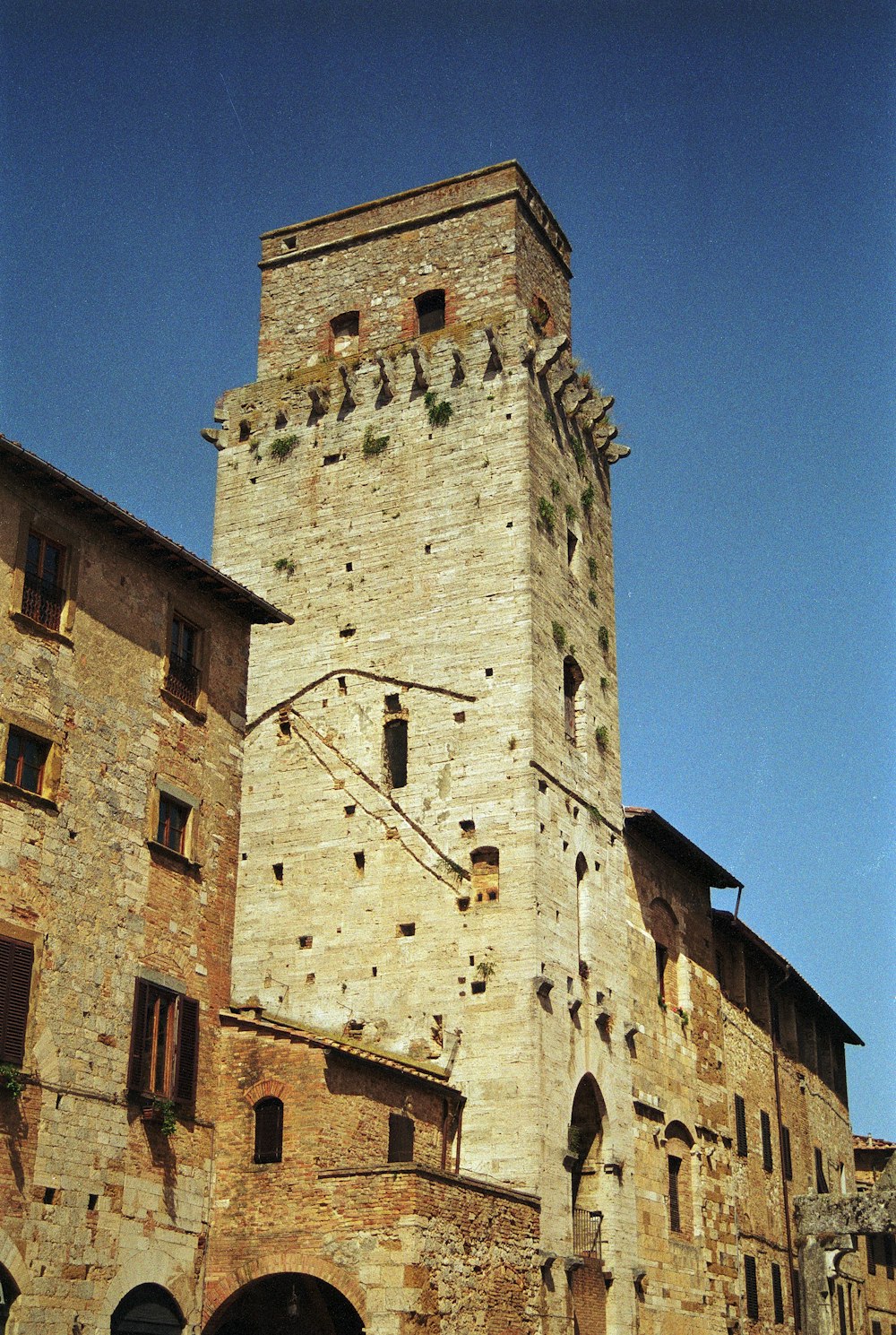 a tall brick building with a clock on it's side