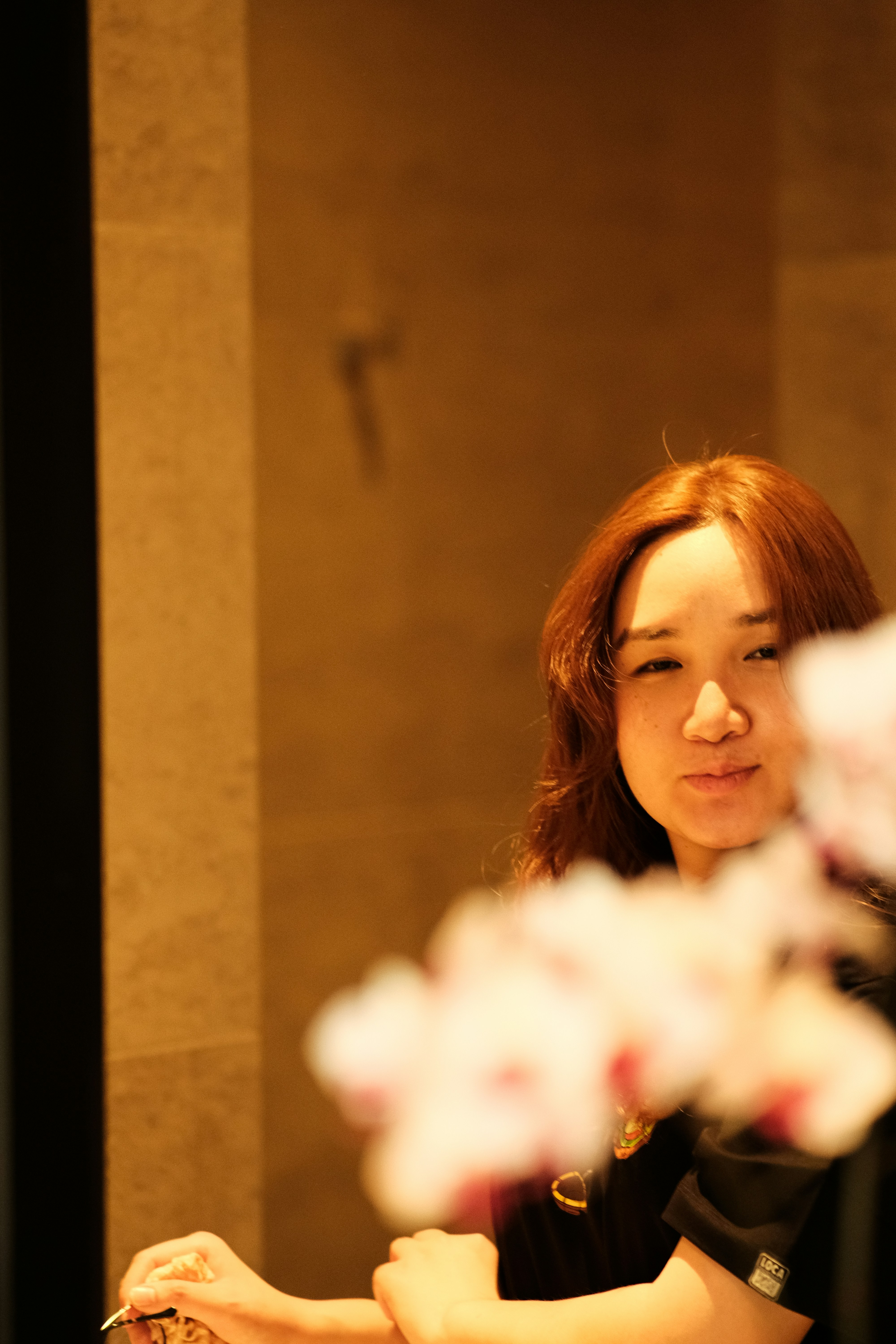 Woman with auburn hair smiling warmly, bright natural light