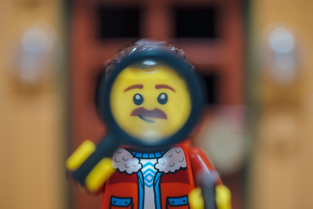 a lego man holding a magnifying glass