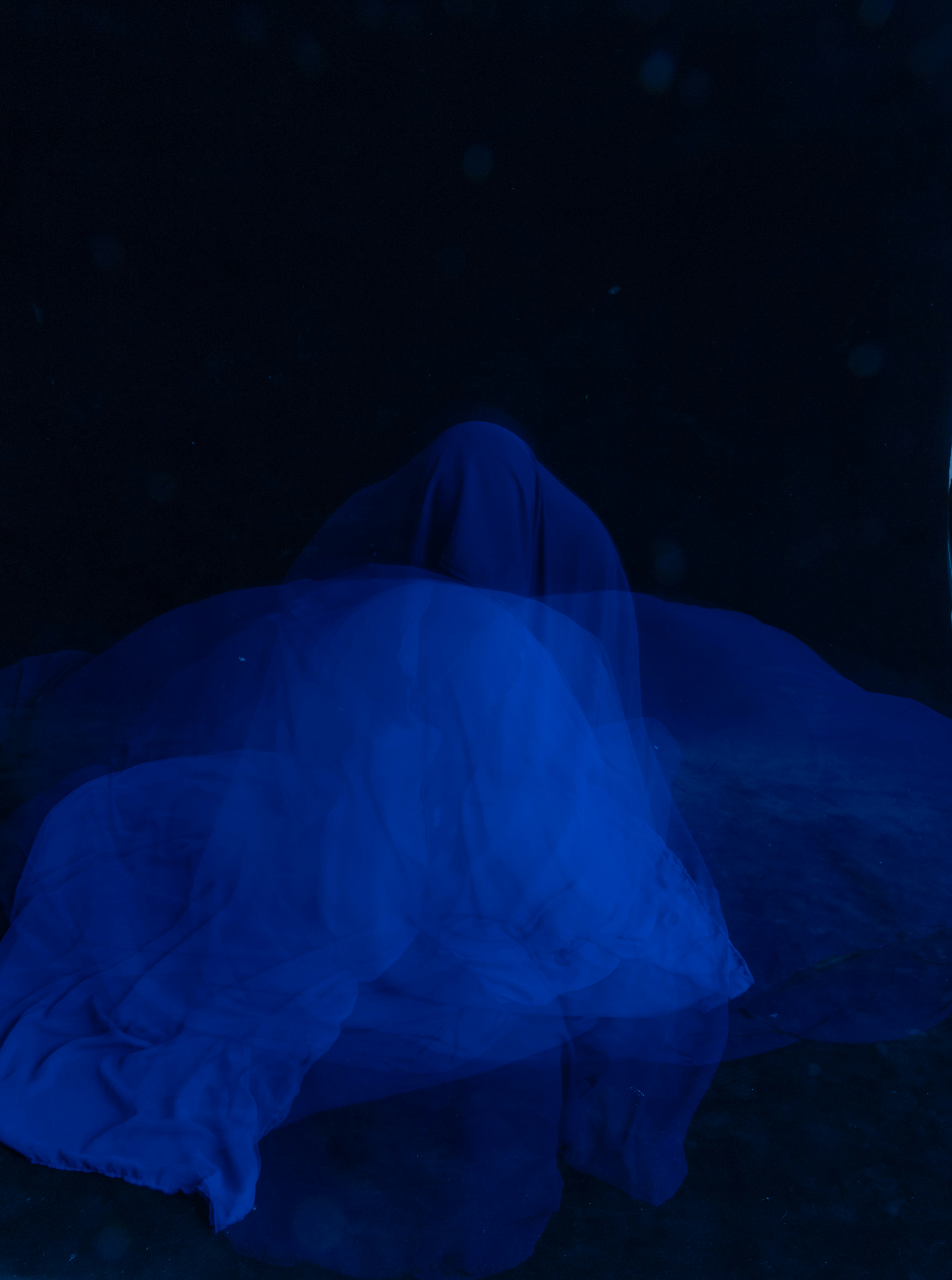 Eine Frau in einem blauen Kleid liegt auf dem Boden