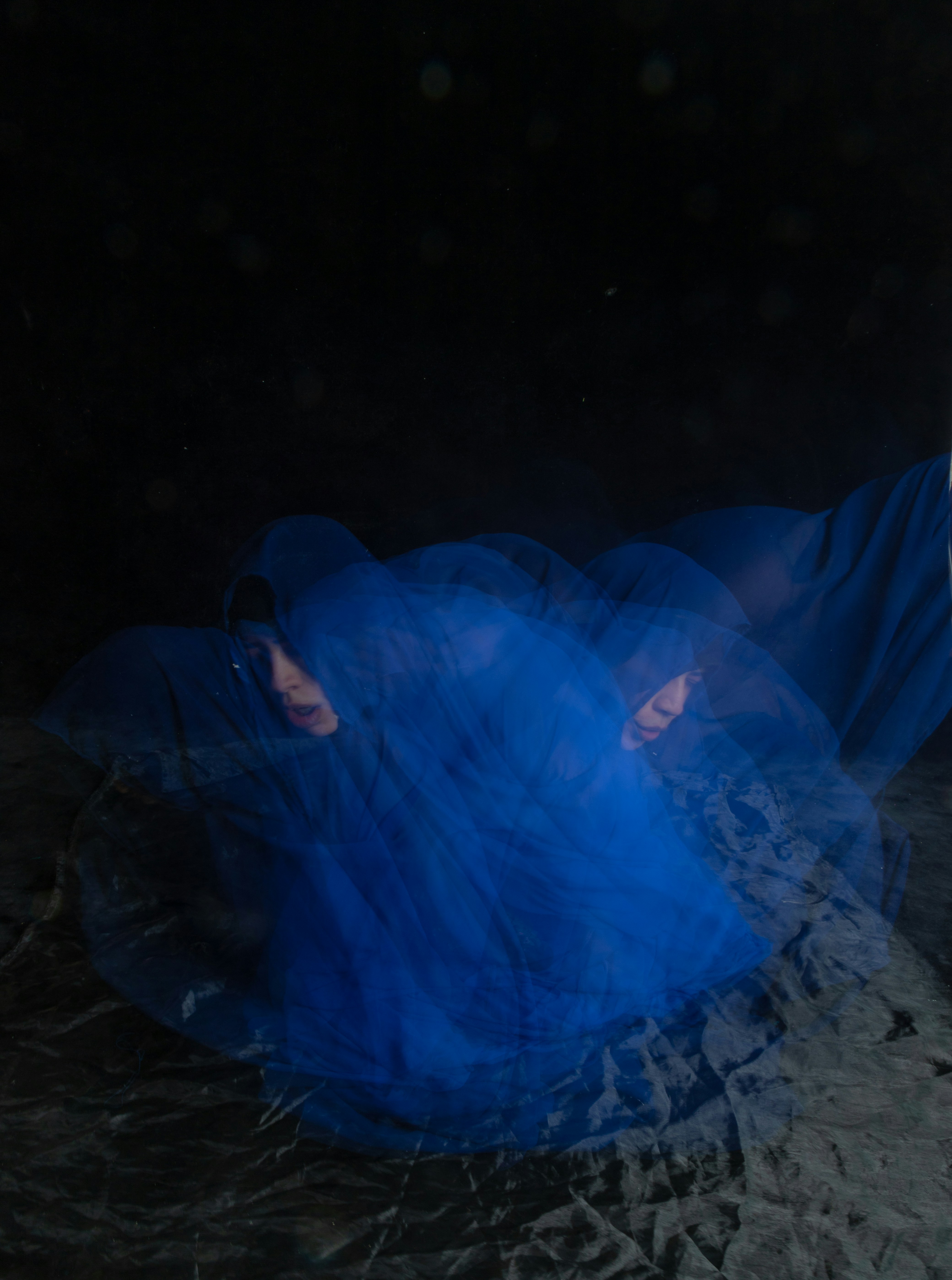 Eine Frau in einem blauen Kleid liegt auf dem Boden