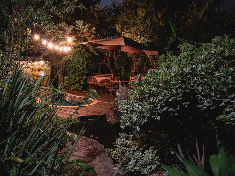 a patio with tables and umbrellas lit up at night