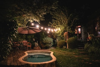 a hot tub in the middle of a garden at night