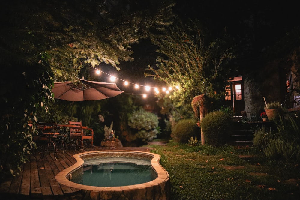 a hot tub in the middle of a garden at night