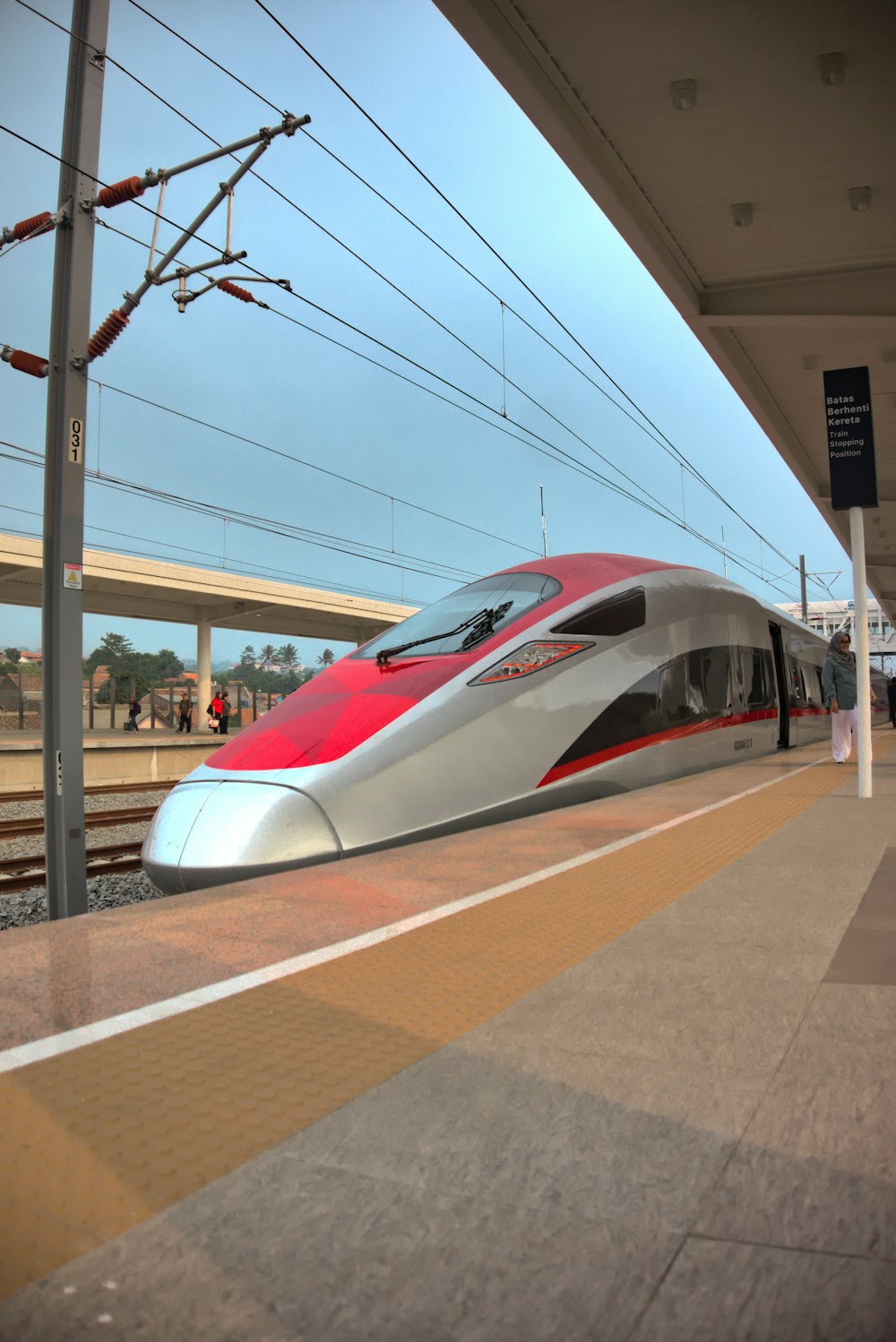 a red and white bullet train pulling into a train station