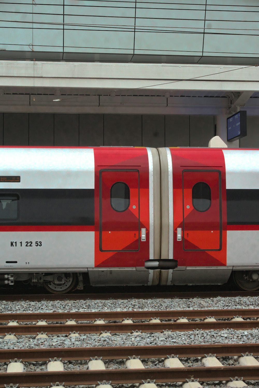 a red and white train parked at a train station