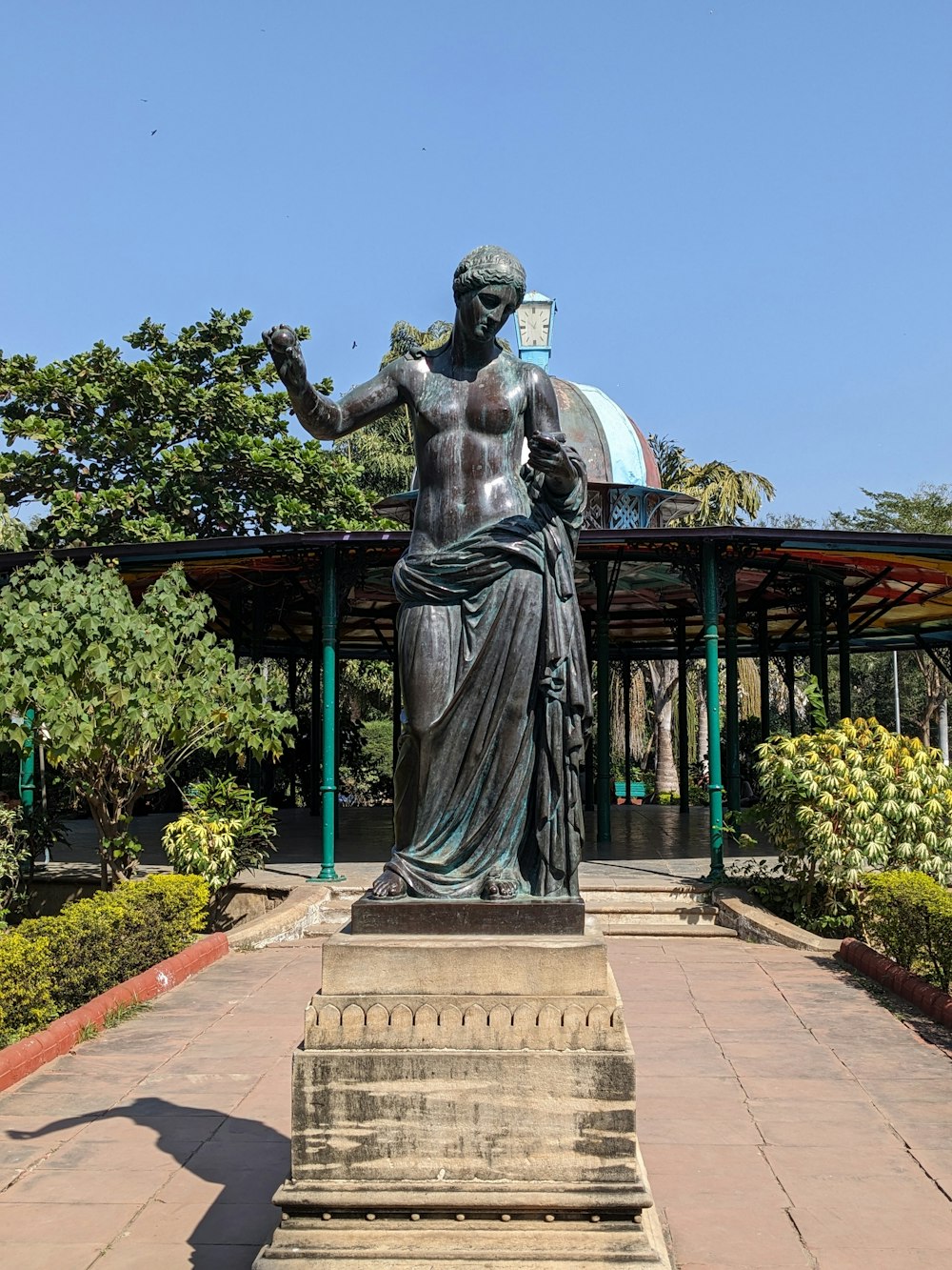 a statue of a man standing in front of a gazebo