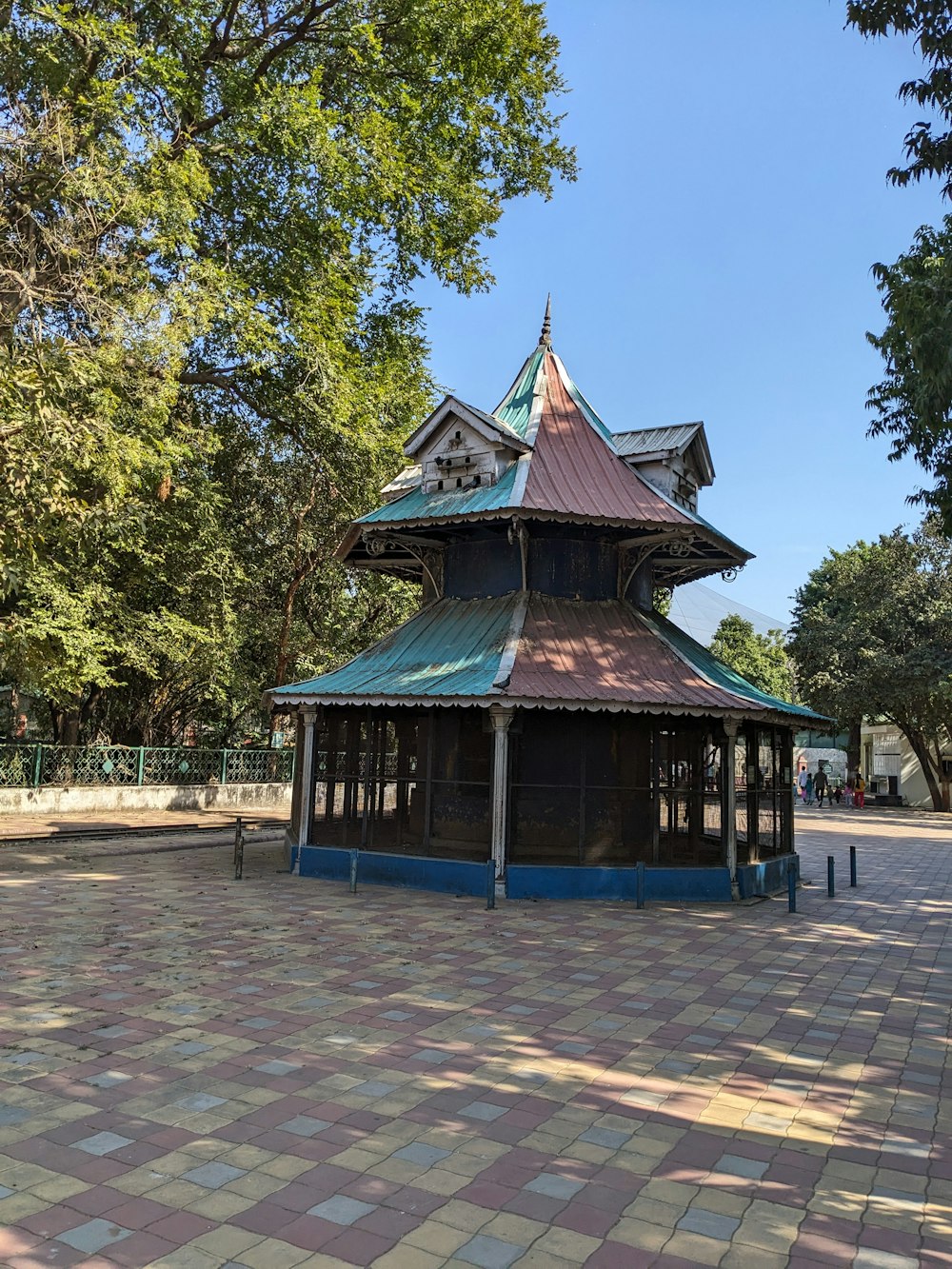 a gazebo in the middle of a park surrounded by trees