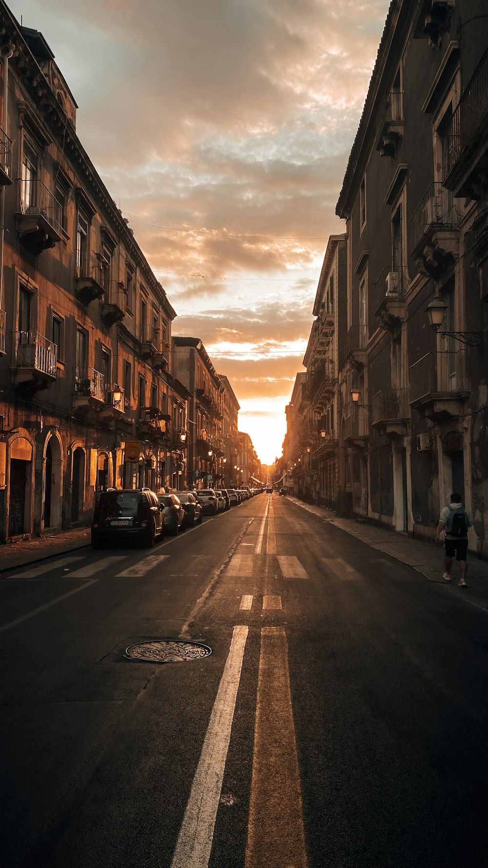 una strada con auto parcheggiate su entrambi i lati