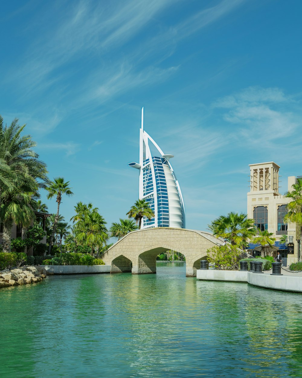 a bridge over a body of water with a building in the background