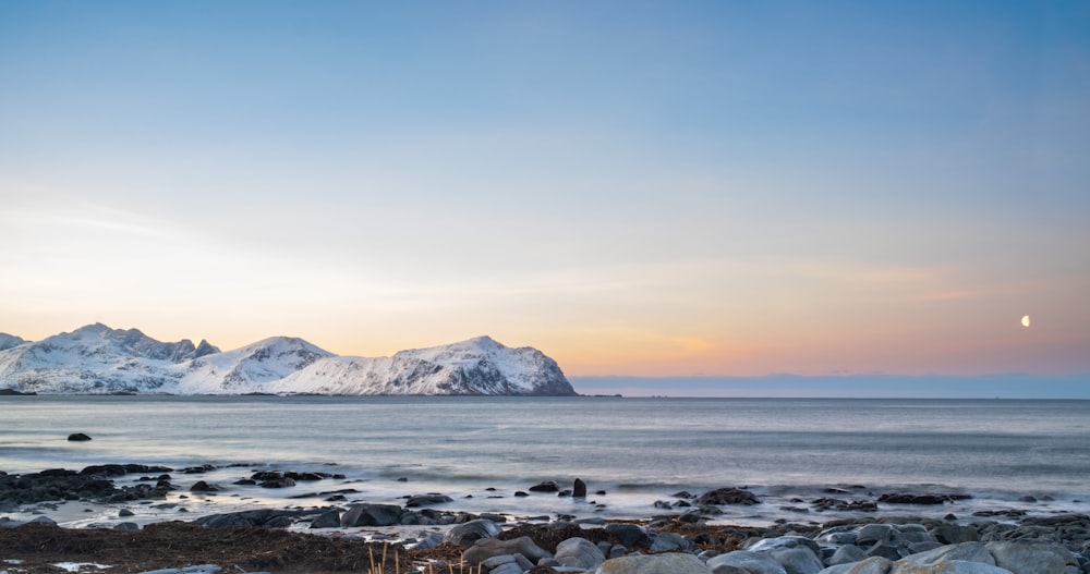 a view of a mountain range from a rocky beach