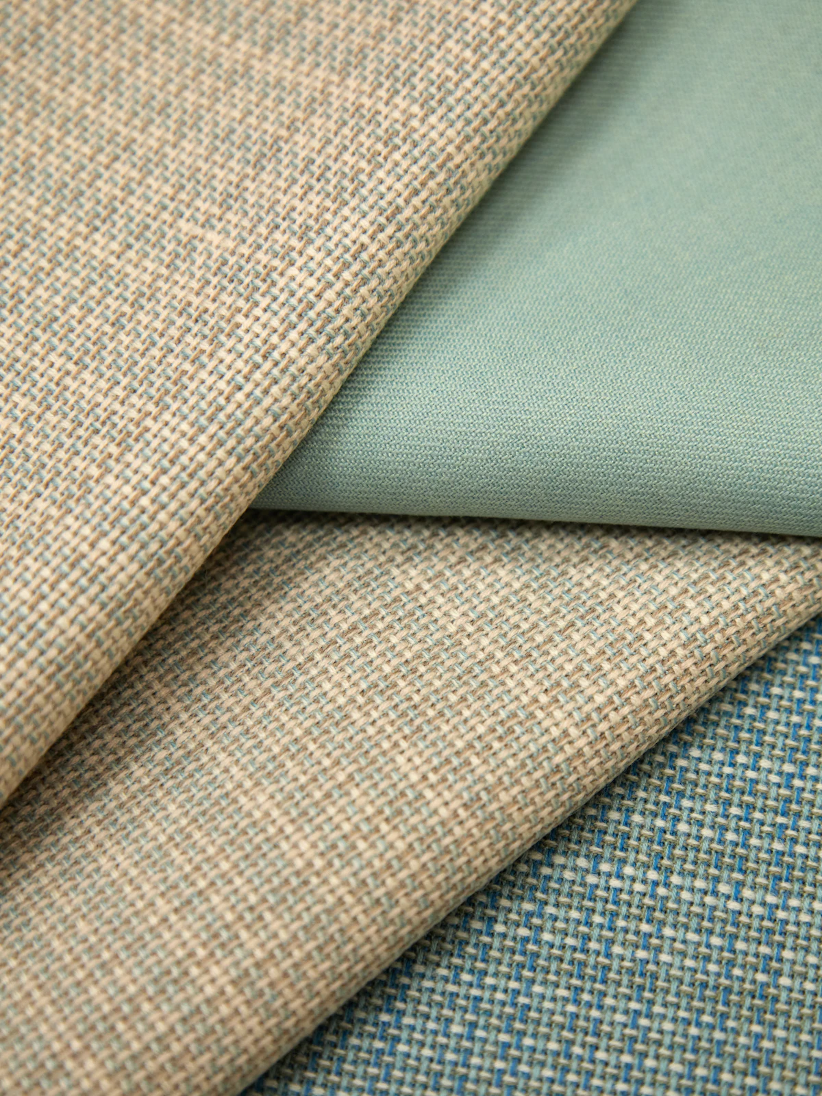 Close-up of several different colored fabric swatches laid side by side, the kind of subtle color differences that are hard to judge by eye alone