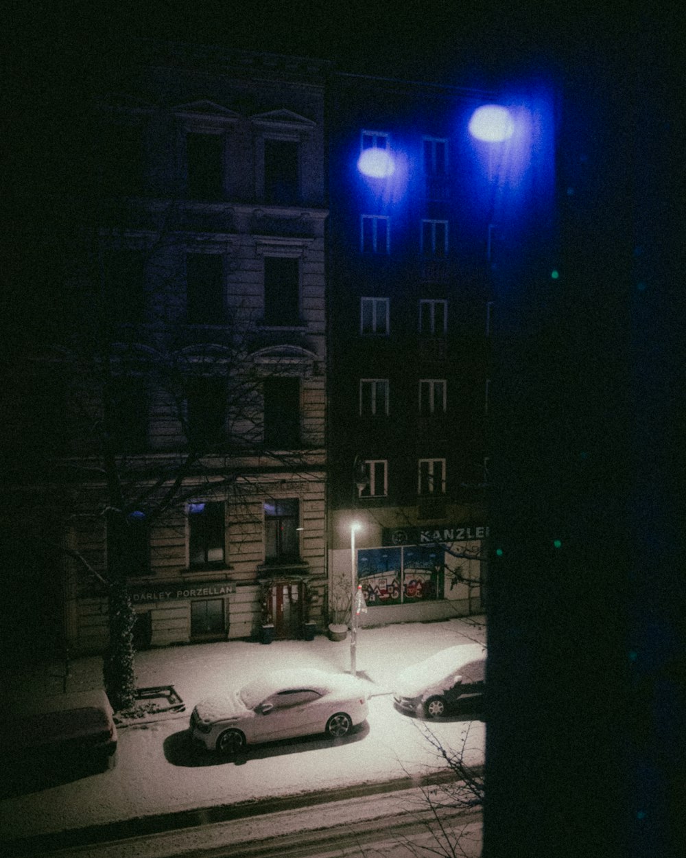 a car parked on a snowy street at night