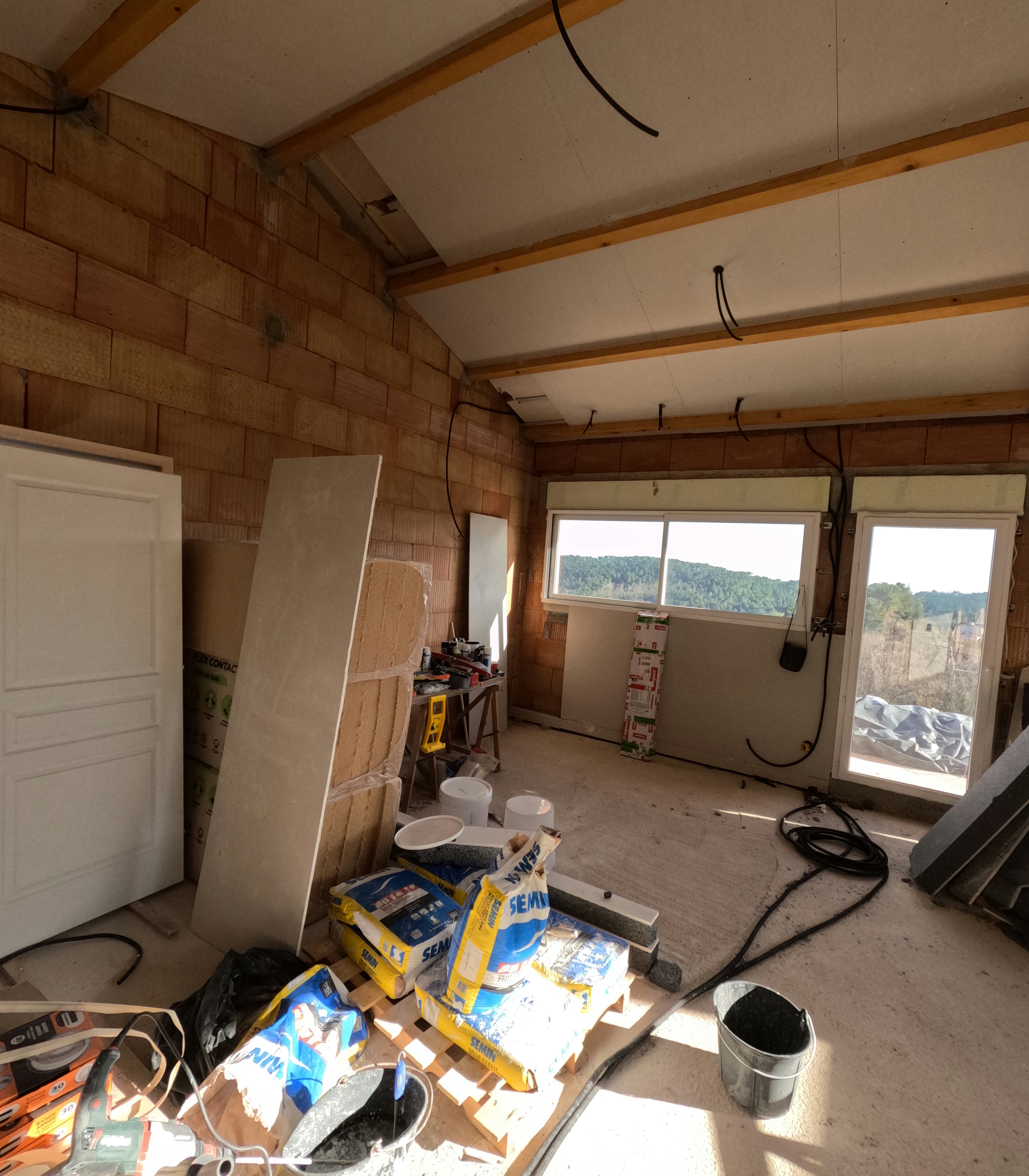 Bright well-lit construction interior with blueprints and tools on clean workbench, open airy space