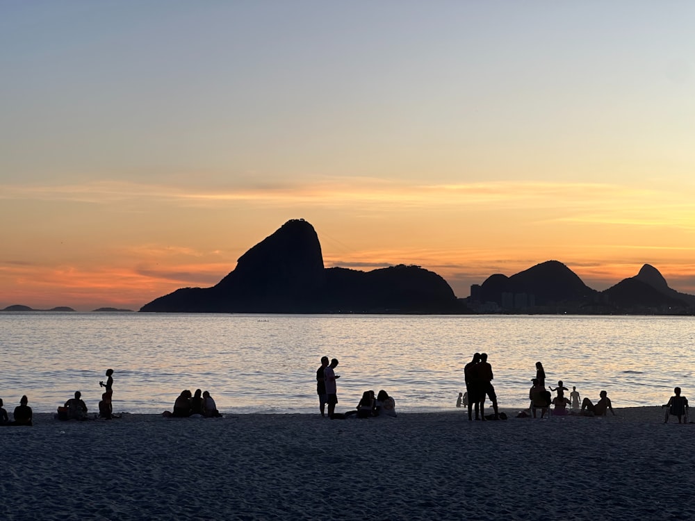 a group of people standing on top of a sandy beach