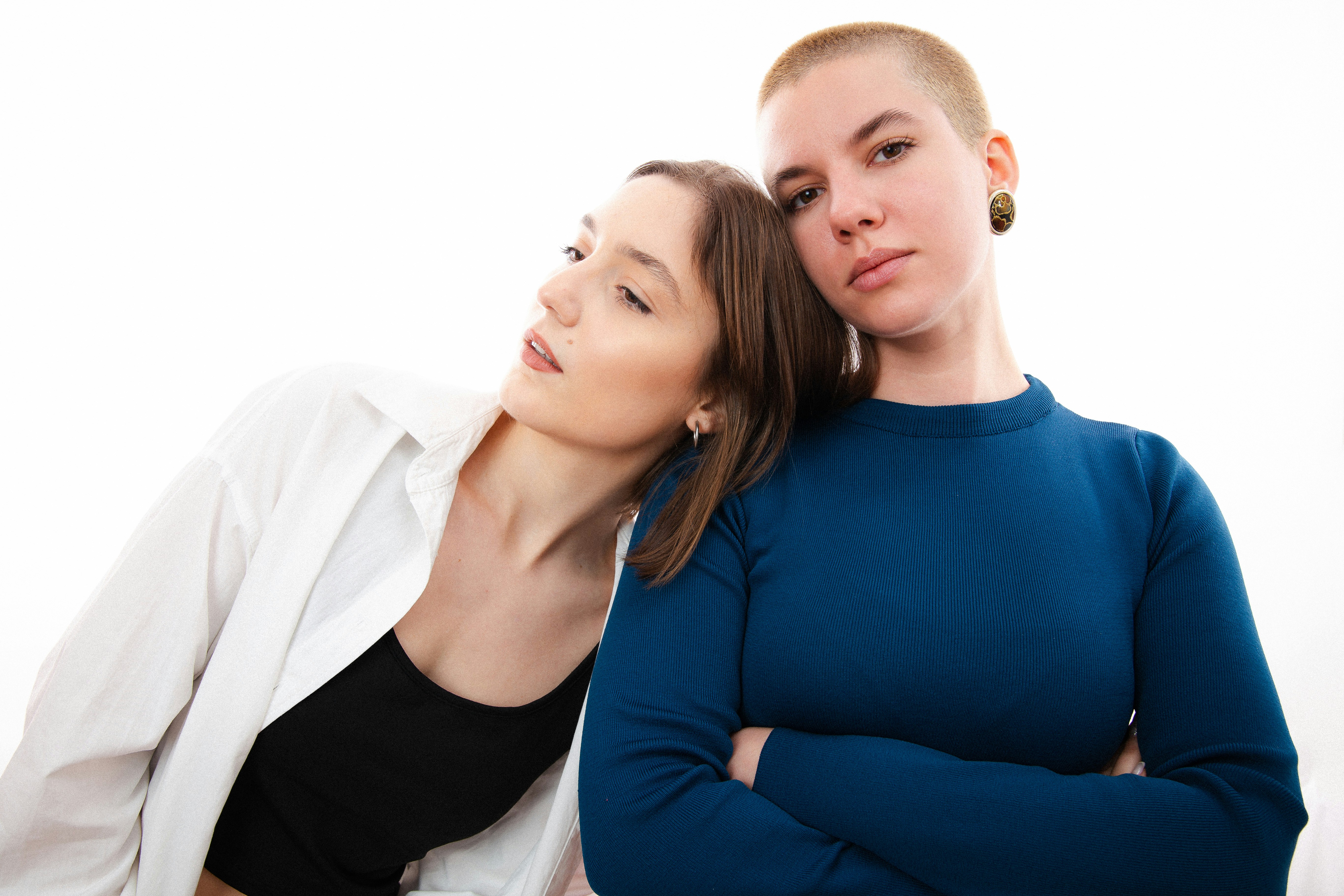 two women standing next to each other in front of a white background