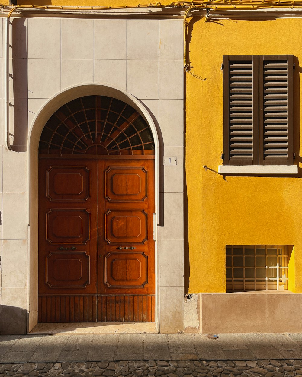 a yellow building with a red door and window