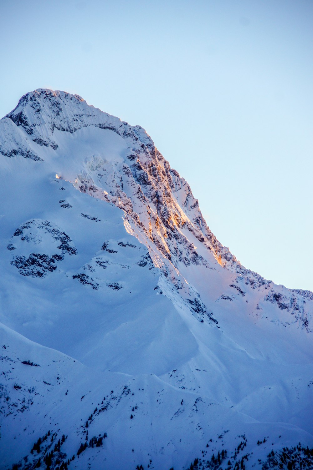 a large mountain covered in snow with a sky background