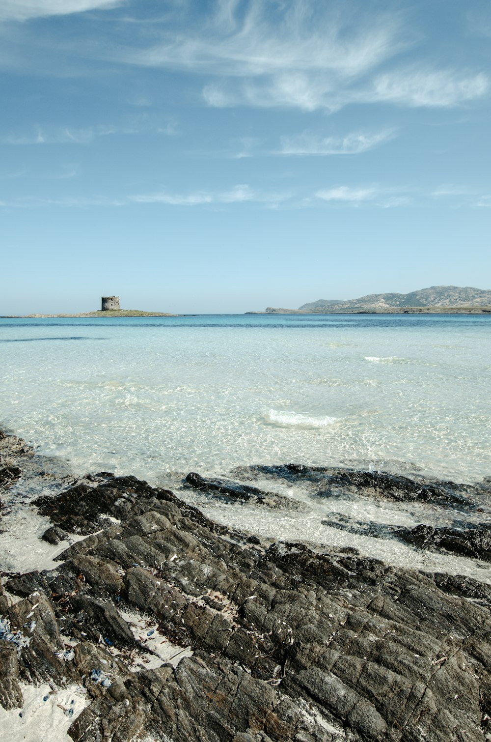 a large body of water sitting next to a rocky shore