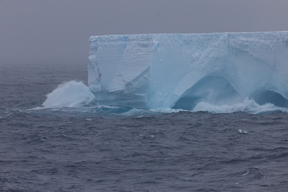 a large iceberg floating in the middle of the ocean