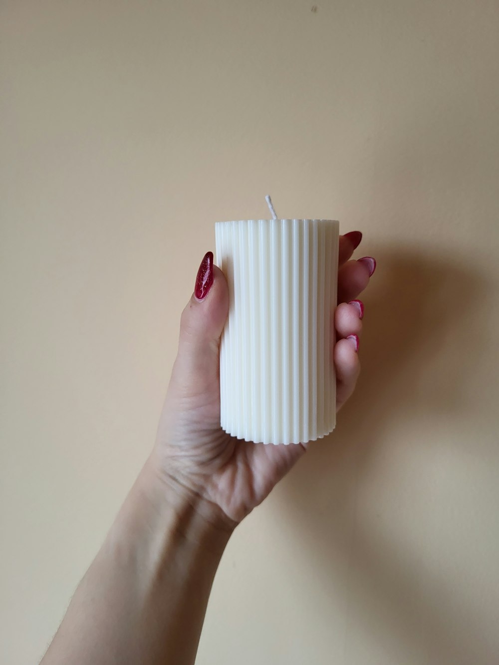 a woman holding a white candle in her hand