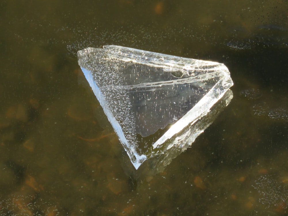 a triangle shaped object floating on top of a body of water