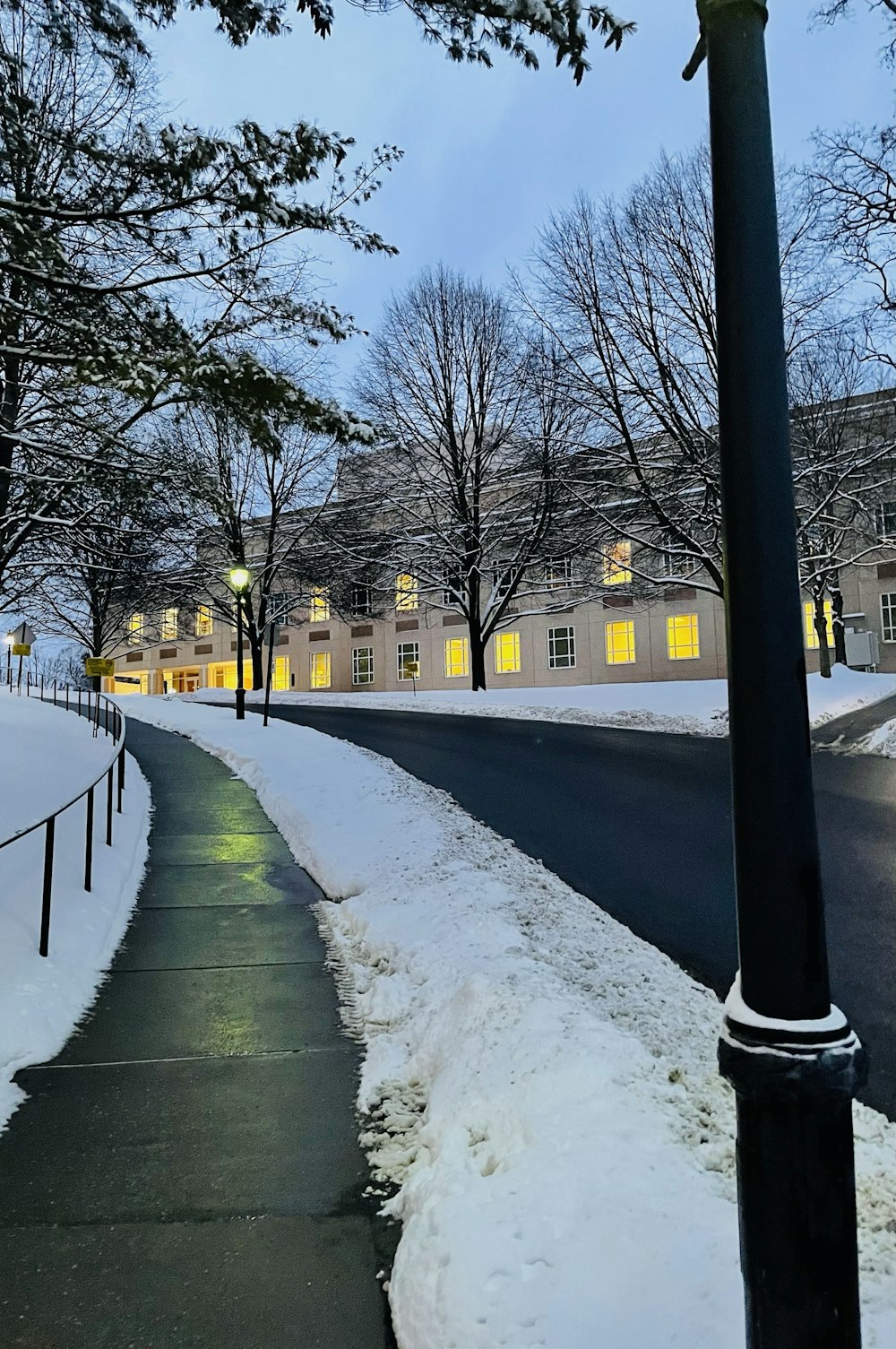 a street light on a snowy street in front of a building