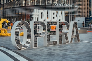 a sign that says dubai opera in front of a building