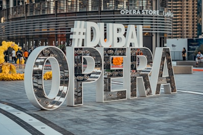a sign that says dubai opera in front of a building