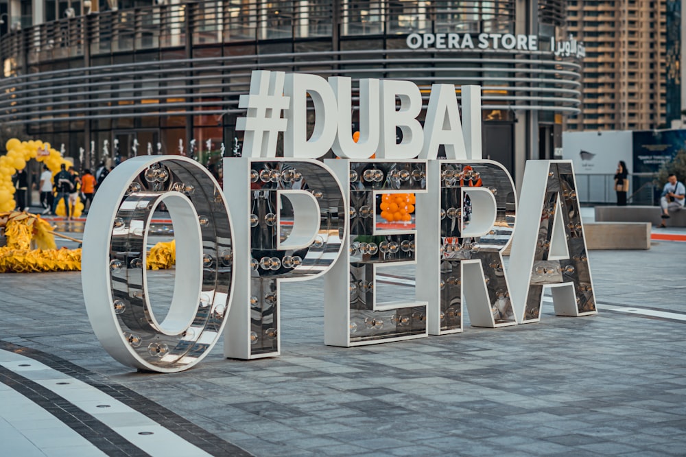 a sign that says dubai opera in front of a building