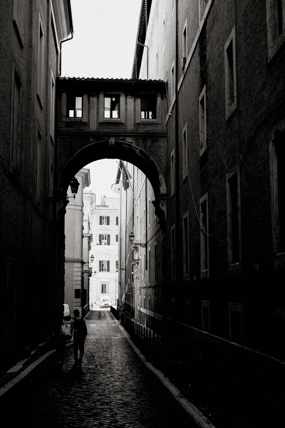 a black and white photo of a person walking down a street