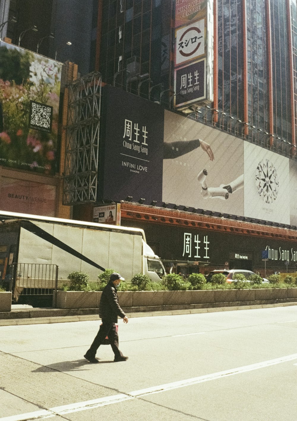 a man walking across a street next to tall buildings