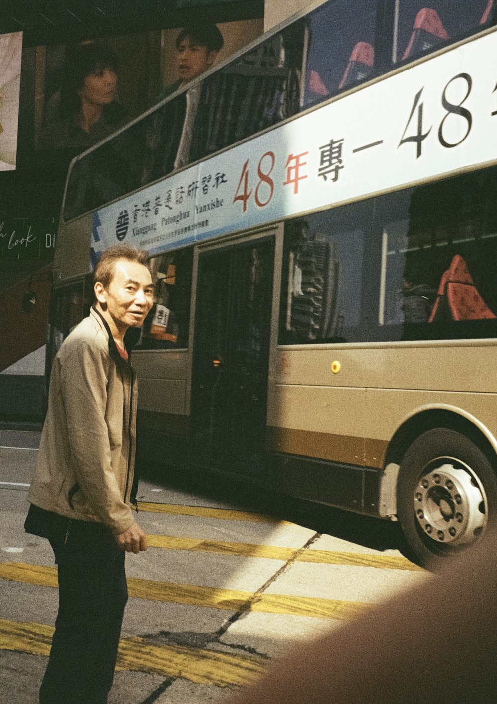 un uomo in piedi davanti a un autobus su una strada