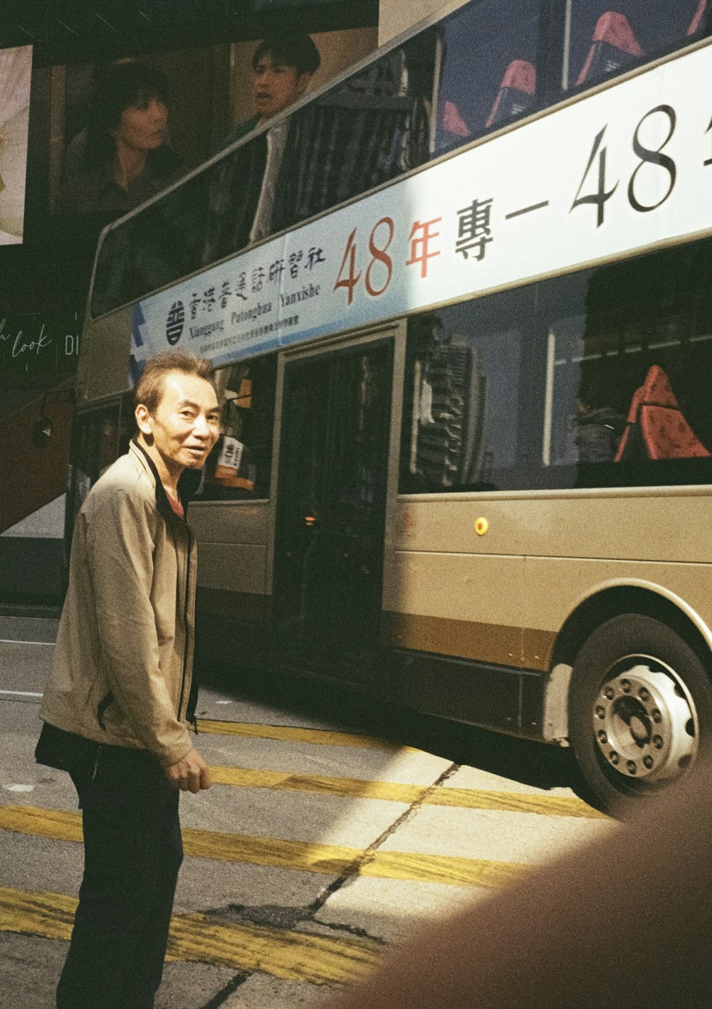 a man standing in front of a bus on a street