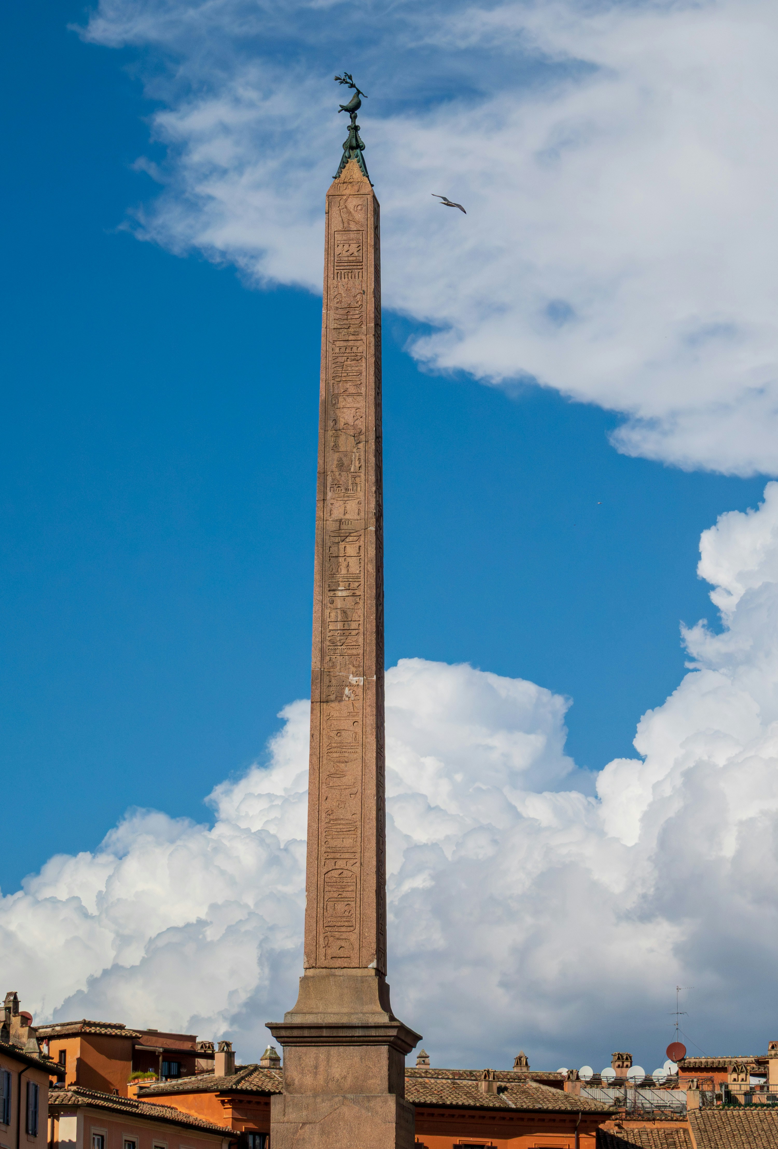 Ancient stone obelisk against blue sky, monumental scale