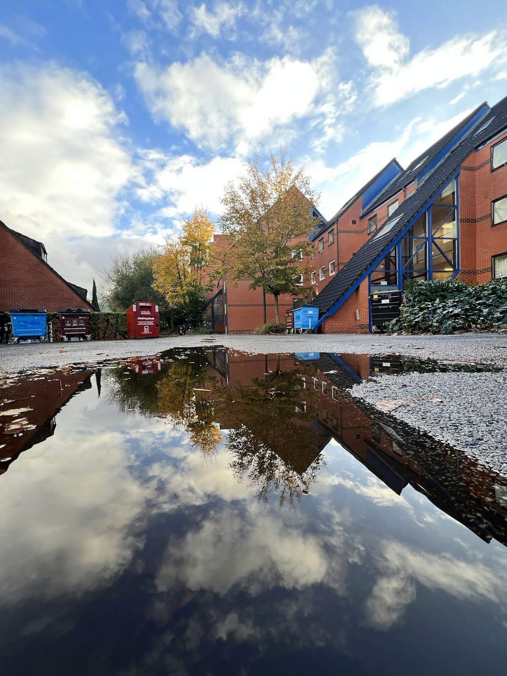 a reflection of a building in a puddle of water