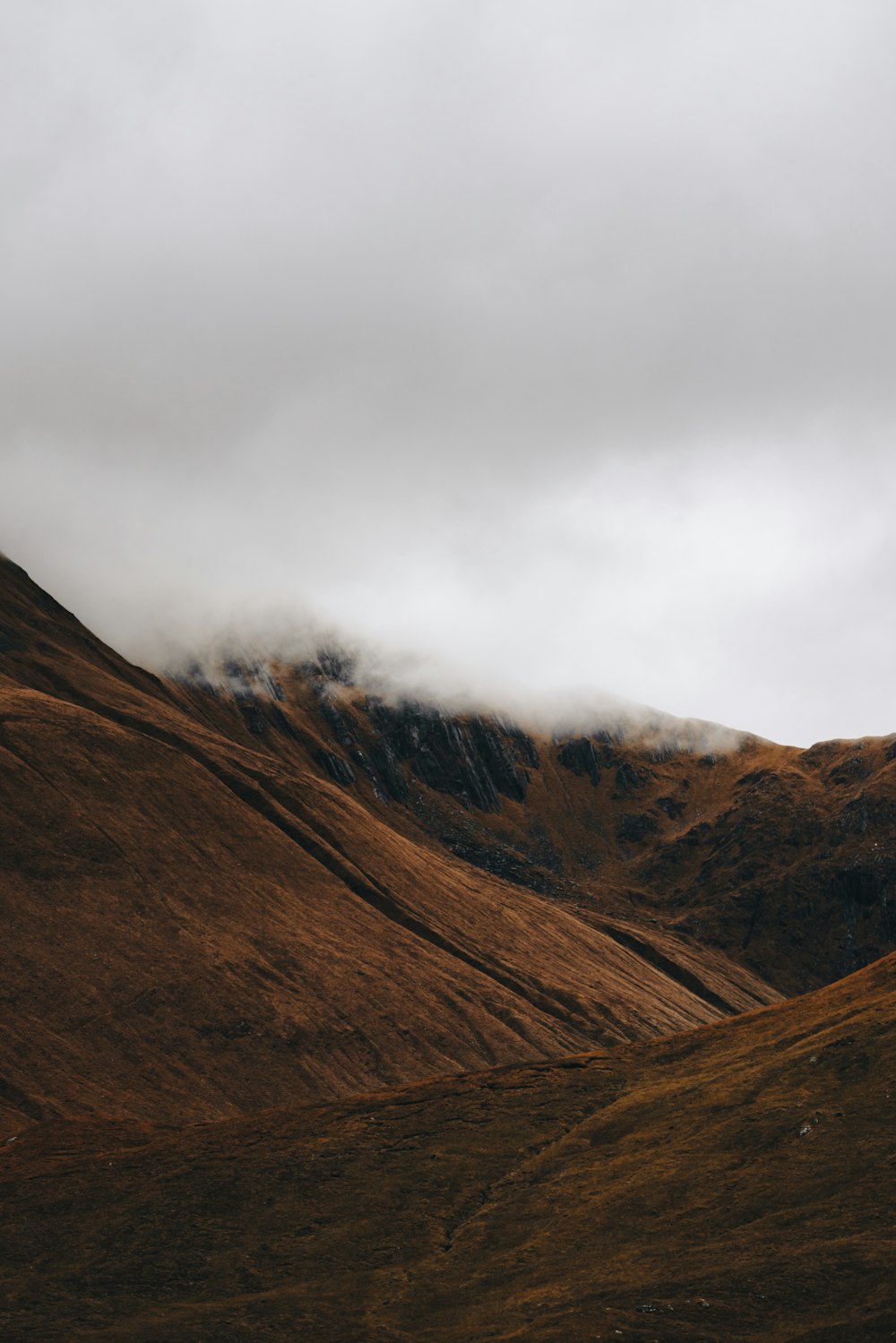 a mountain range with a cloudy sky in the background